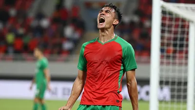 Mid-30s forward, lean, intense expression, drenched in sweat, head tilted back as he shouts triumph after the winning goal;